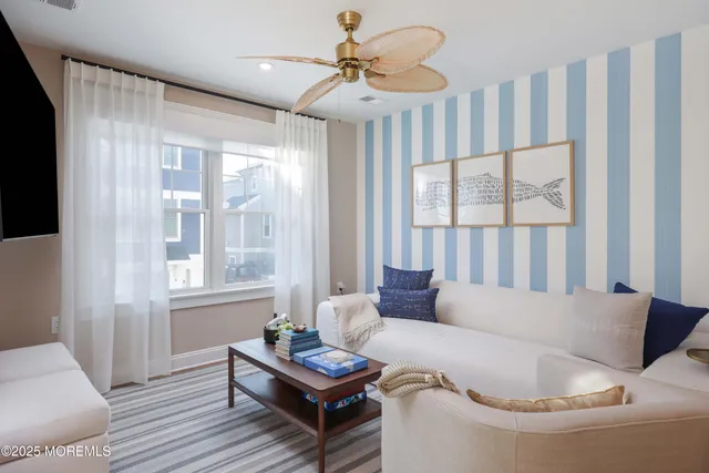 a living room with furniture a large window and wooden floor