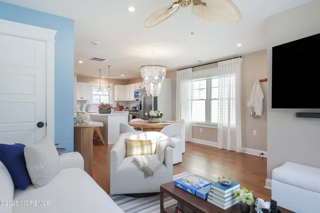 a living room with furniture a flat screen tv and kitchen view