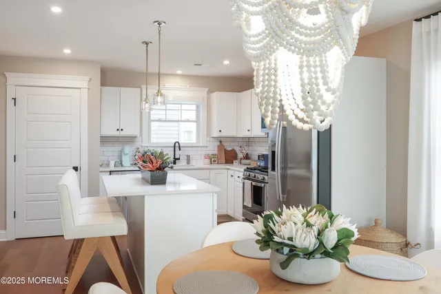 a kitchen with stainless steel appliances granite countertop a refrigerator a sink a stove and white cabinets