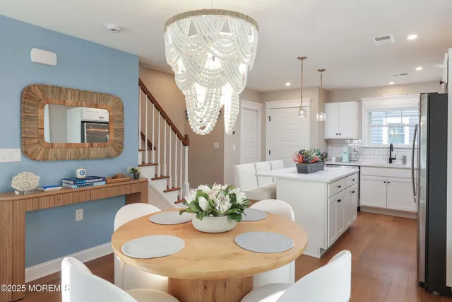 a kitchen with stainless steel appliances kitchen island granite countertop a white cabinets a stove a dining table and chairs