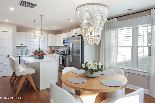 a kitchen with stainless steel appliances granite countertop a dining table and chairs