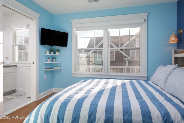 a bedroom with a bed and a flat tv screen in a bedroom