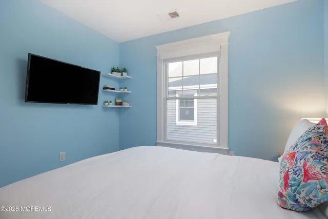 a bedroom with a bed and flat screen tv