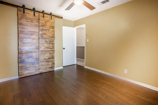 an empty room with wooden floor and door