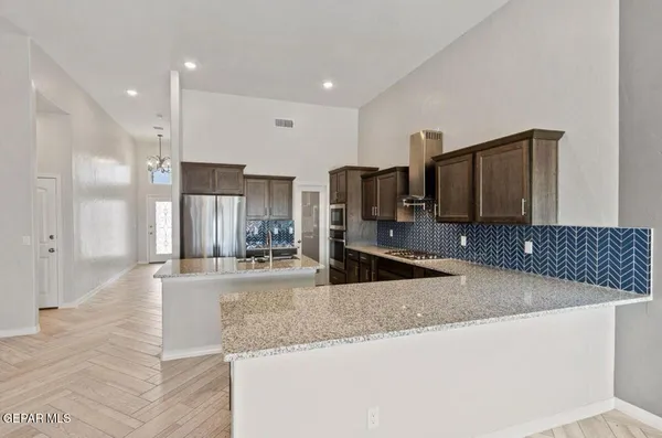 a large kitchen with kitchen island granite countertop a sink and stainless steel appliances
