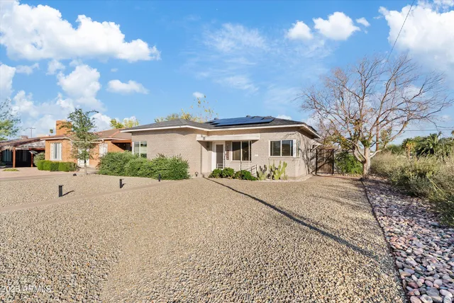 a white house with a large tree in front of it