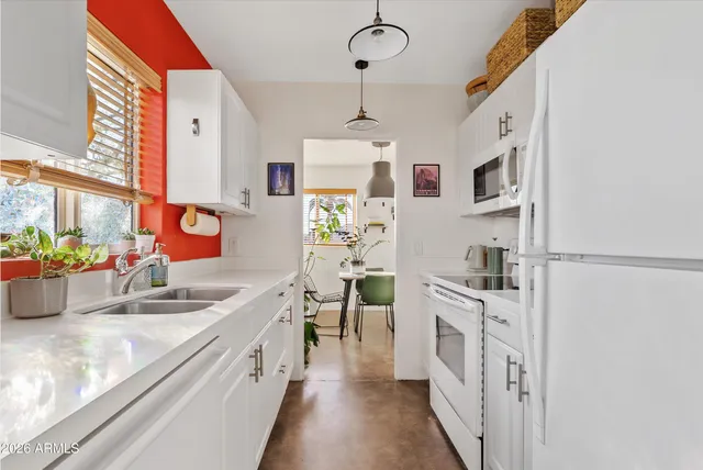 a kitchen with stainless steel appliances sink and wooden floor