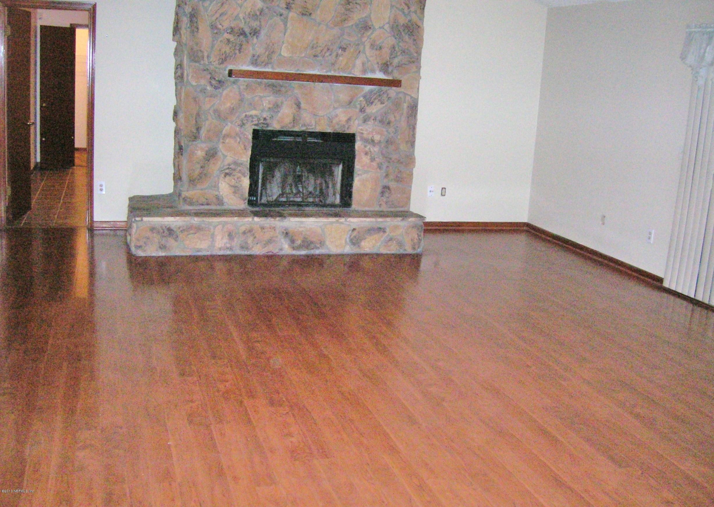 11069 Reading Road Jacksonville, FL 32257 - Photo 5 of 18 an empty room with wooden floor and fireplace