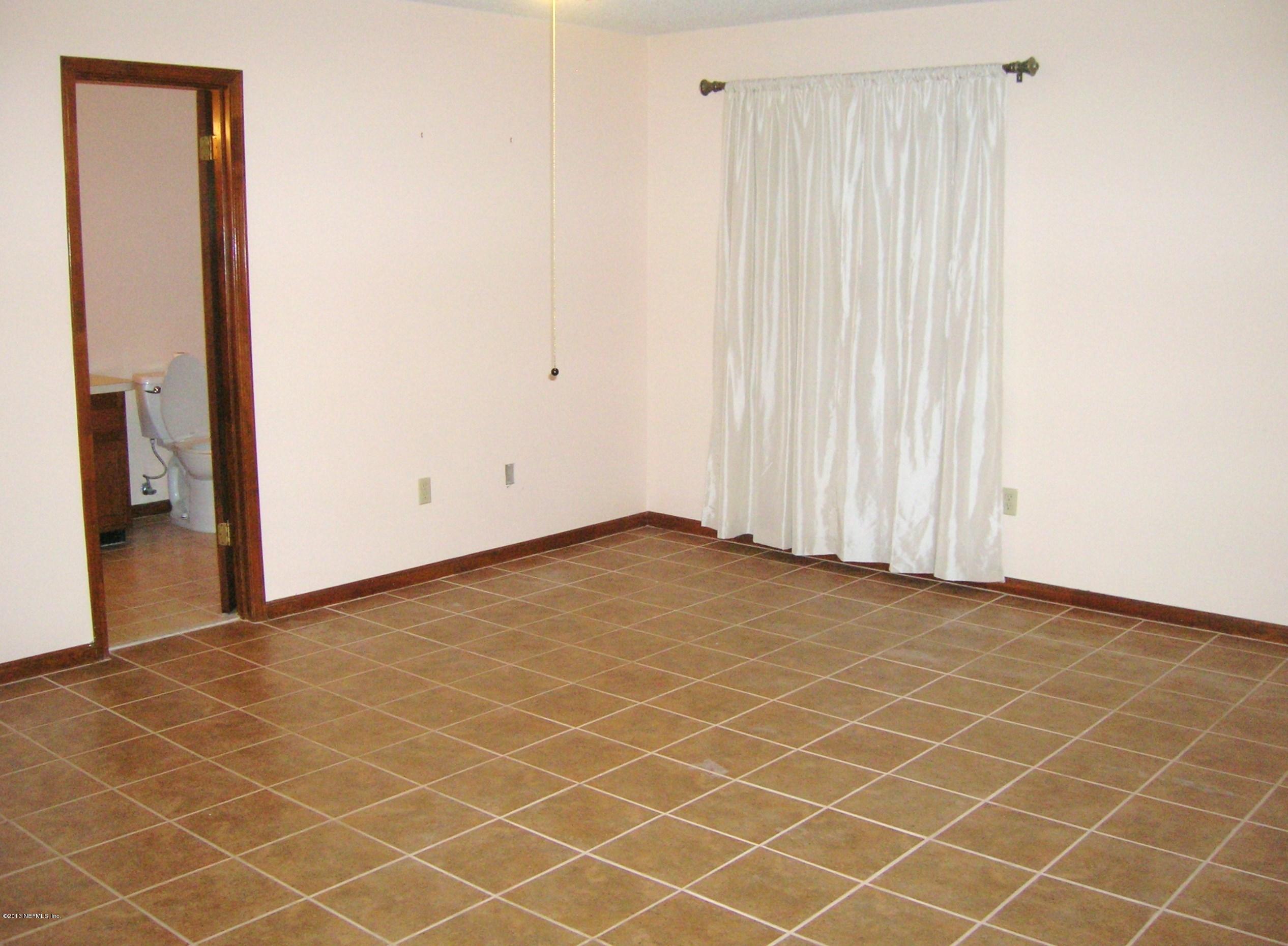 11069 Reading Road Jacksonville, FL 32257 - Photo 6 of 18 an empty room with wooden floor and windows