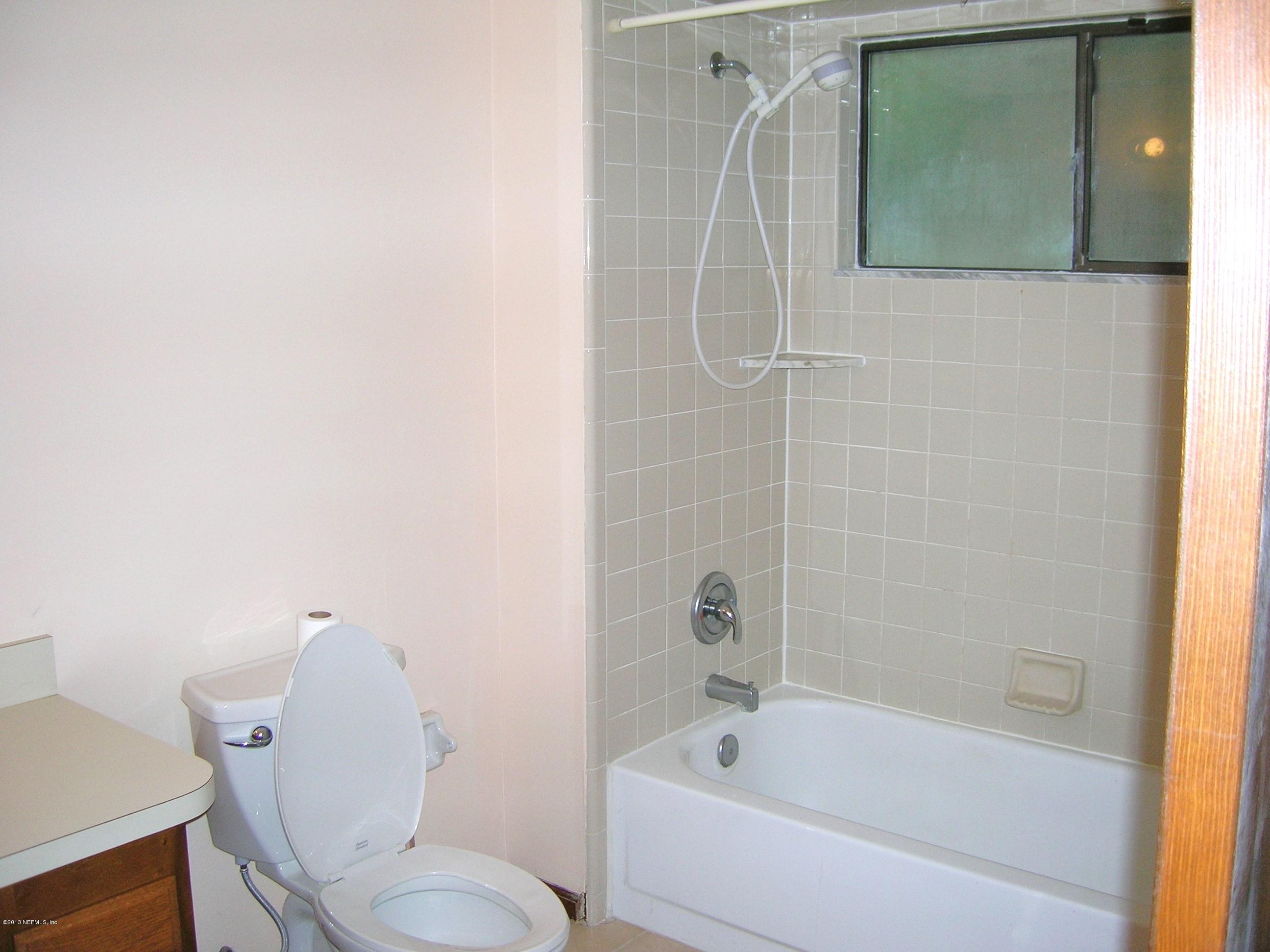 11069 Reading Road Jacksonville, FL 32257 - Photo 8 of 18 a white toilet sitting next to a bath tub shower
