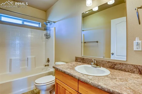 a bathroom with a granite countertop sink toilet mirror and shower