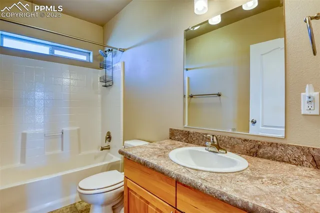 a bathroom with a granite countertop sink toilet mirror and shower