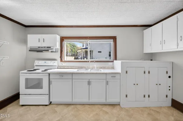 a kitchen with white cabinets and white appliances