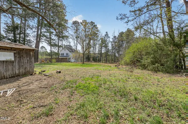 a front view of house with yard and trees all around