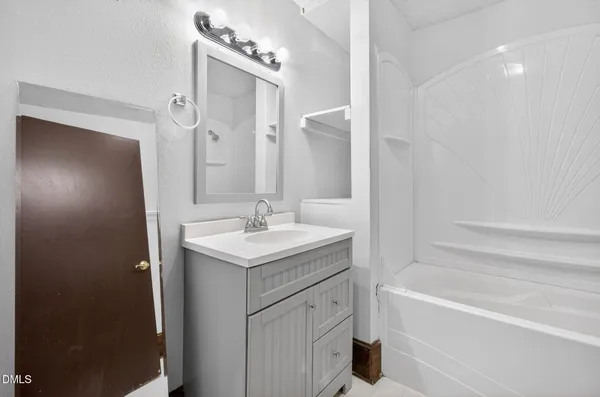 an empty room with wooden floor and a ceiling fan