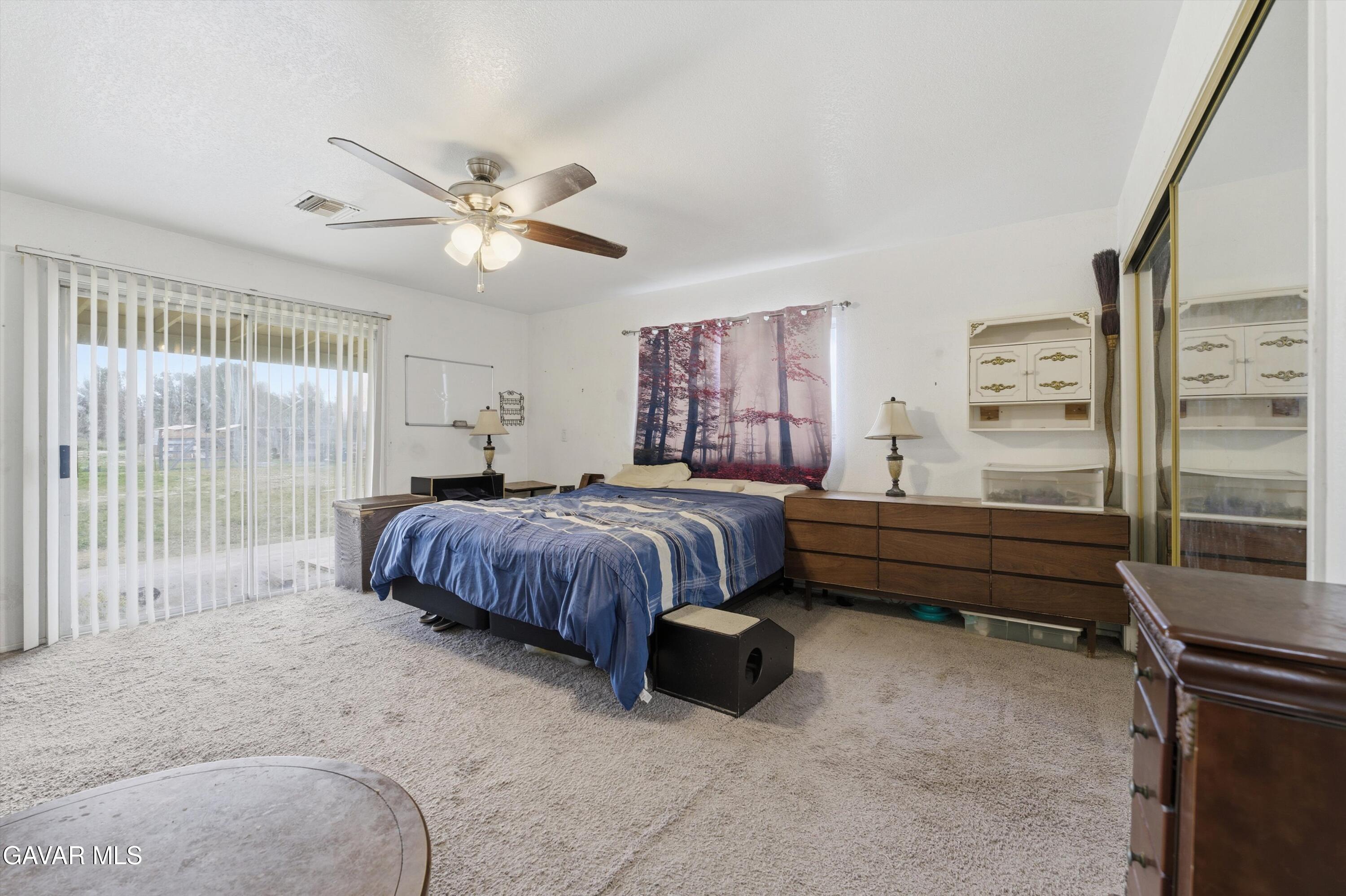 9340 East Ave R 10 Littlerock, CA 93543 - Photo 12 of 33 a spacious bedroom with a bed and a chandelier