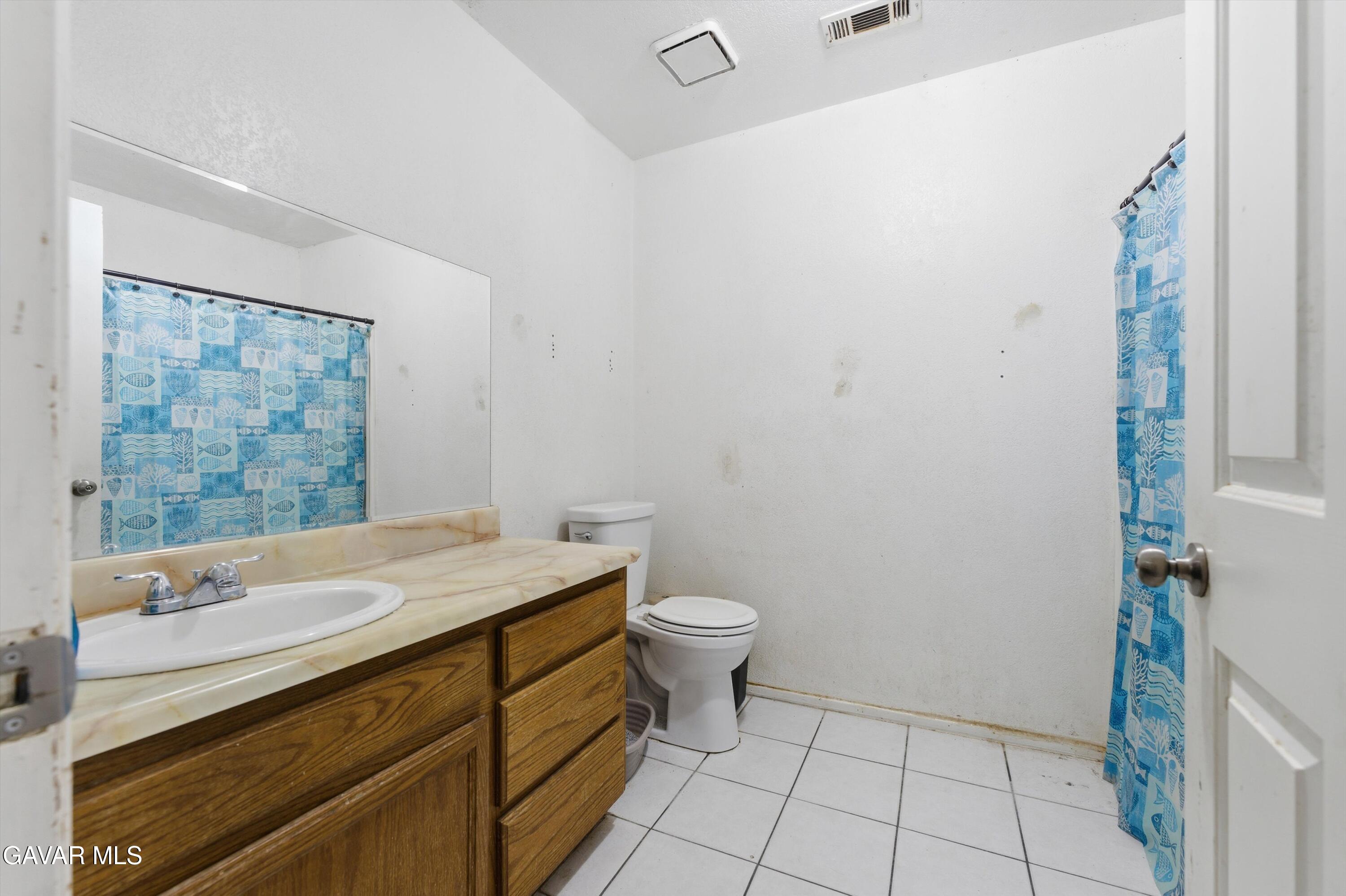 9340 East Ave R 10 Littlerock, CA 93543 - Photo 15 of 33 a bathroom with a sink a toilet and mirror