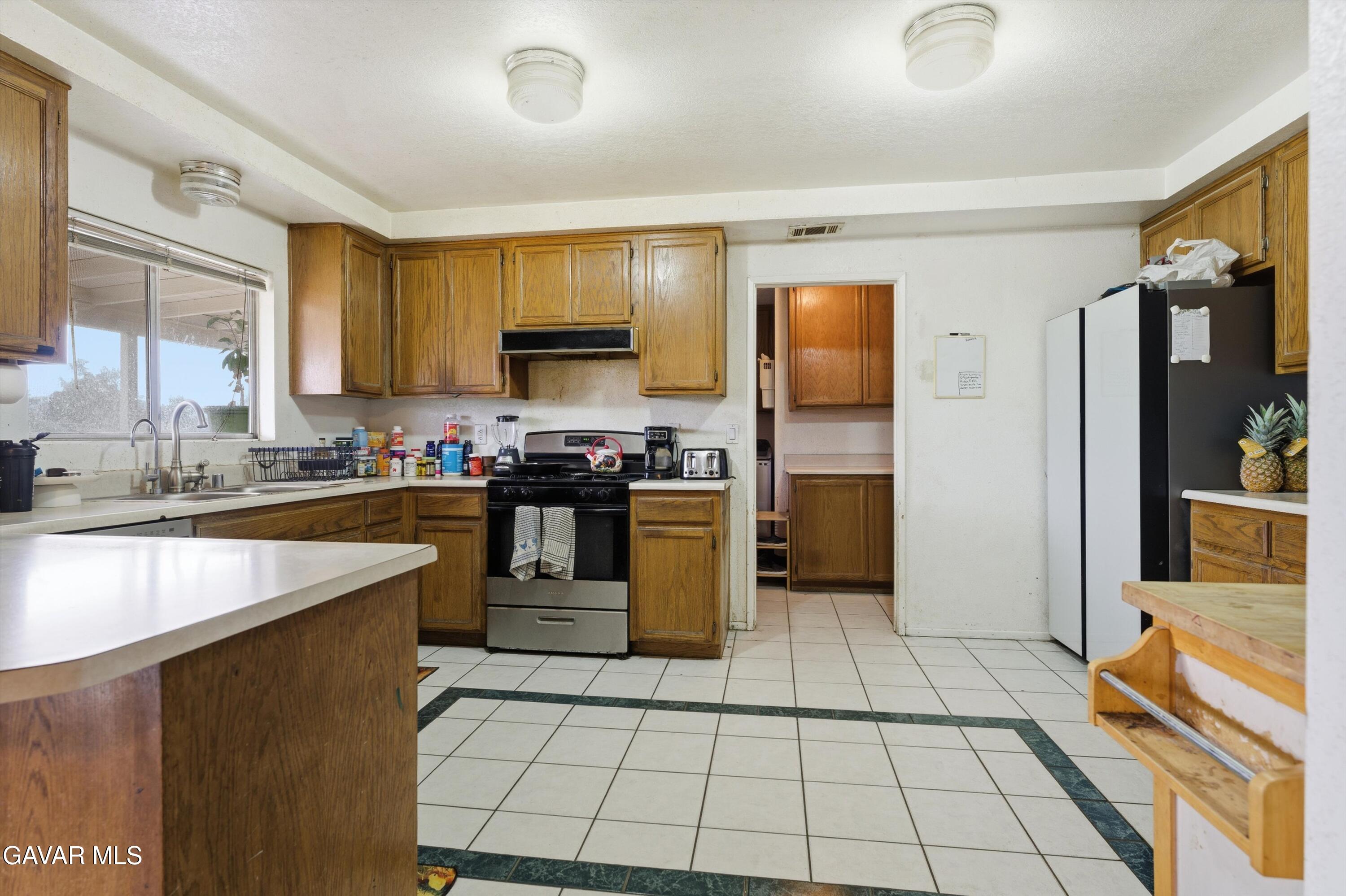 9340 East Ave R 10 Littlerock, CA 93543 - Photo 5 of 33 a kitchen with a sink a counter top space and stainless steel appliances