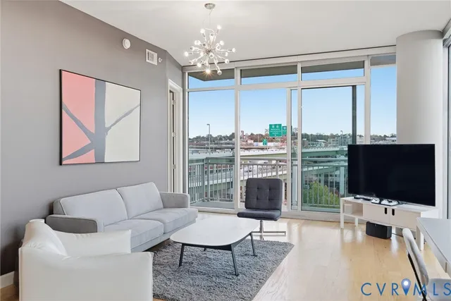 a living room with furniture a flat screen tv and a large window