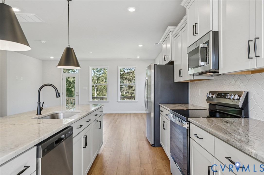 340 Mt Mccauley Way Aylett, VA 23009 - Photo 8 of 48 a kitchen with stainless steel appliances granite countertop a sink a stove and a wooden floors