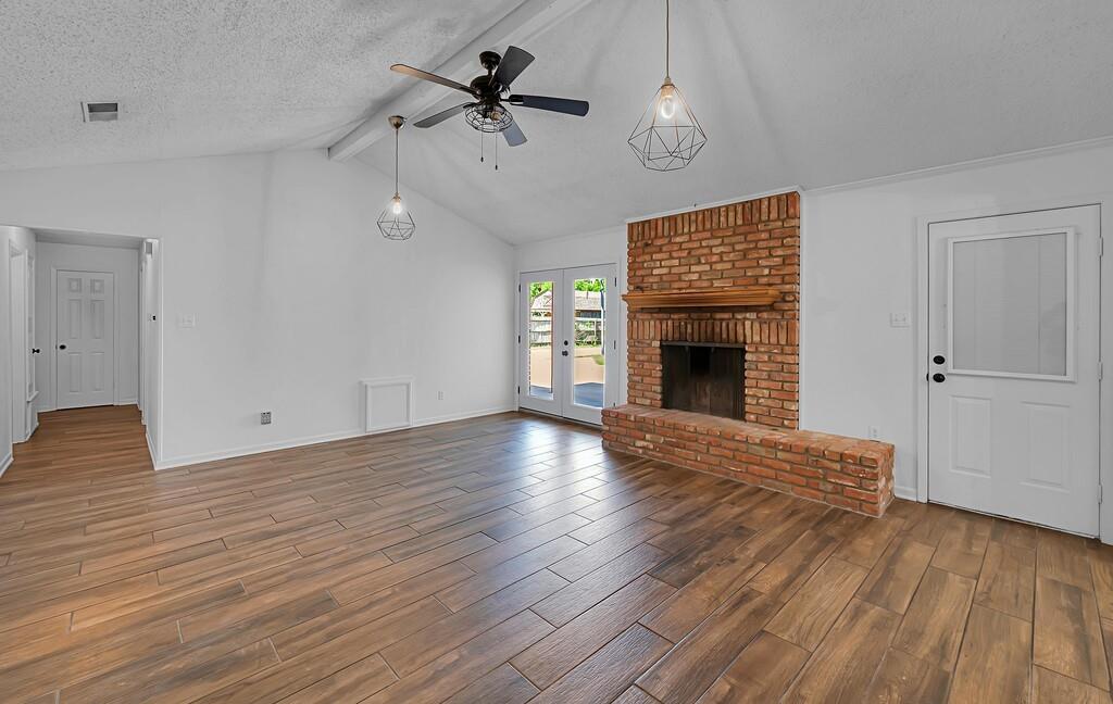 216 Texas Avenue Hewitt, TX 76643 - Photo 5 of 32 a view of an empty room with wooden floor fireplace and a window