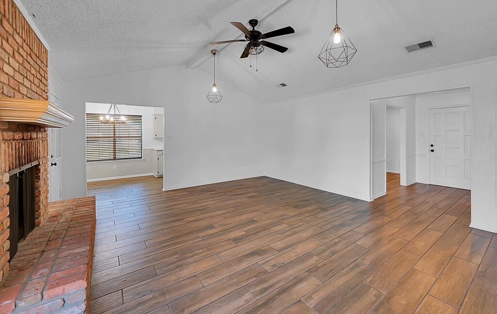 216 Texas Avenue Hewitt, TX 76643 - Photo 6 of 32 an empty room with wooden floor chandelier fan and windows