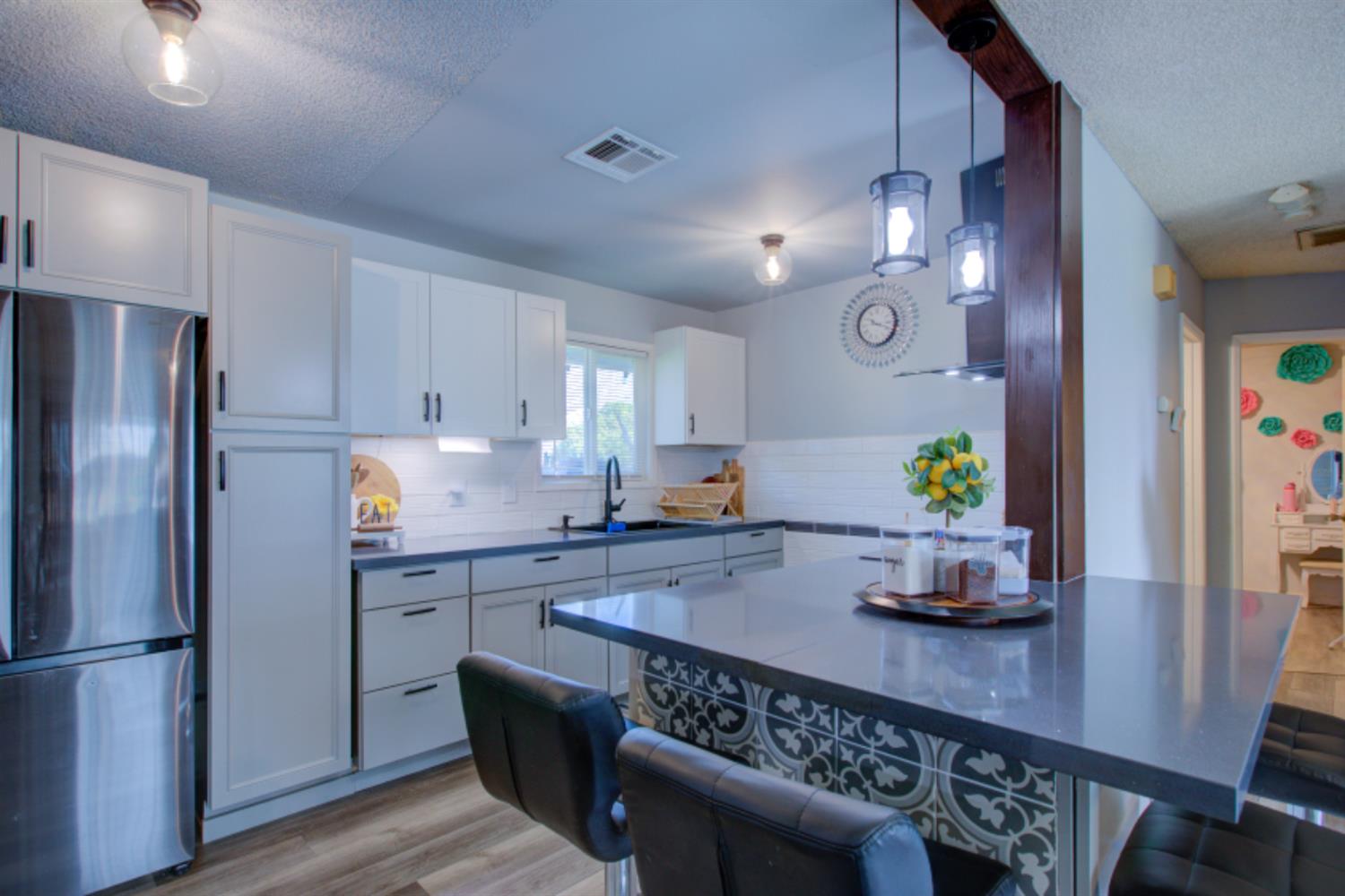 7139 Center Street Winton, CA 95388 - Photo 16 of 36 a kitchen with granite countertop a refrigerator a stove a wooden floor a dining table and chairs