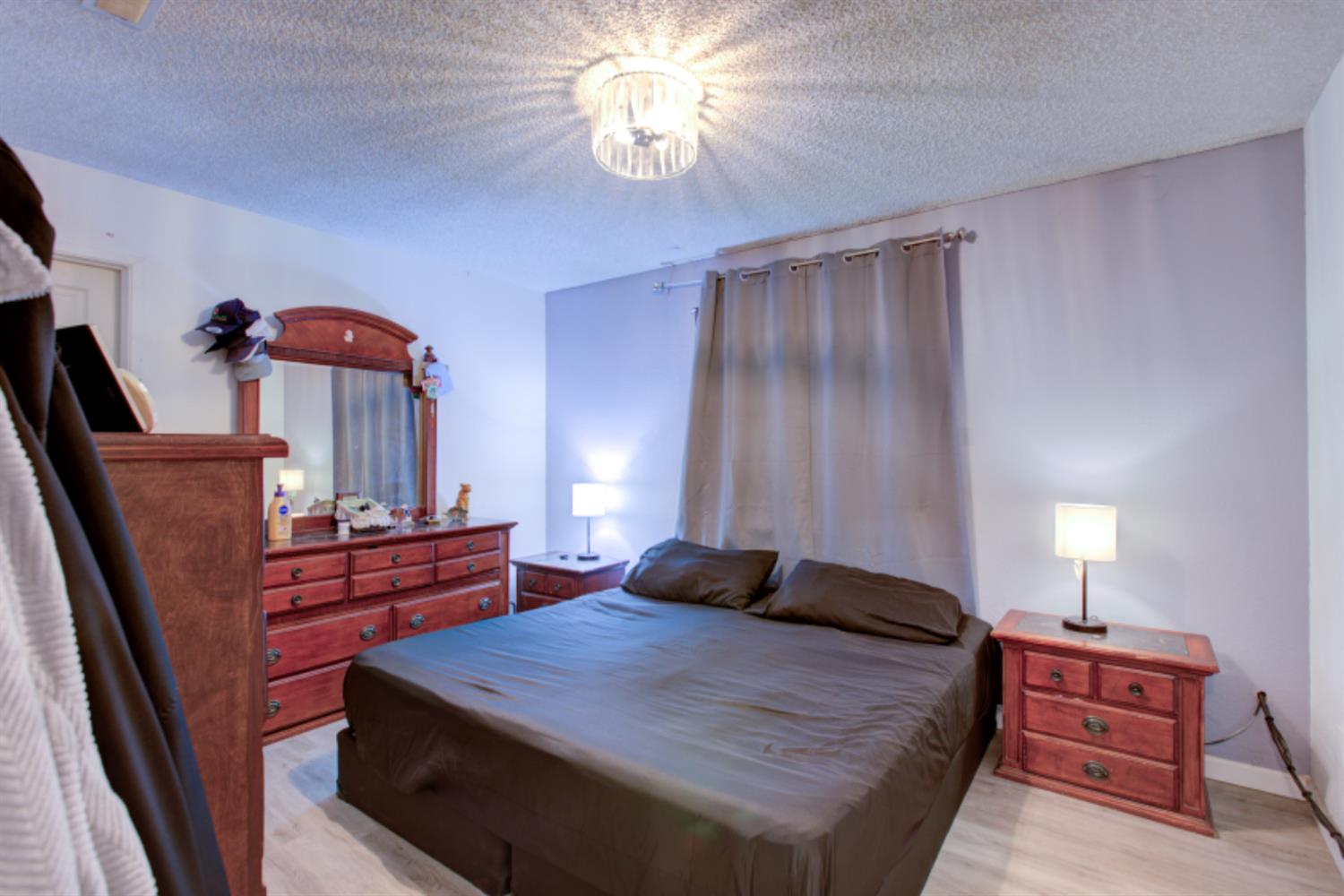 7139 Center Street Winton, CA 95388 - Photo 26 of 36 a bedroom with a bed and a chandelier