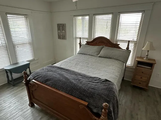 a bedroom with a bed and wooden floor