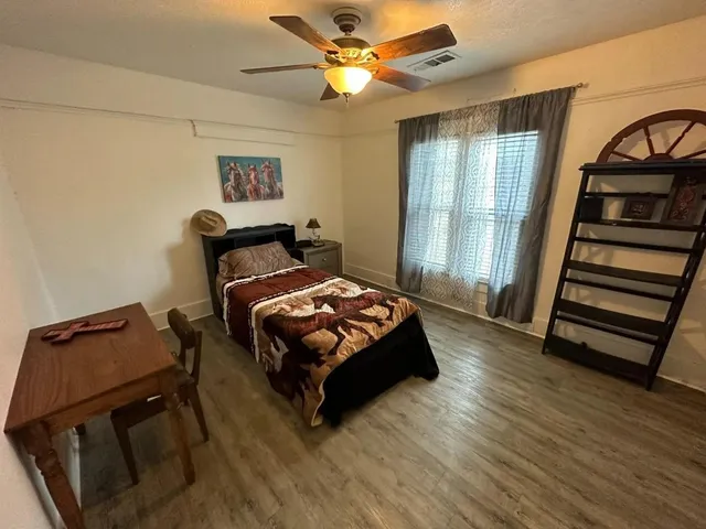 a bedroom with a bed and wooden floor