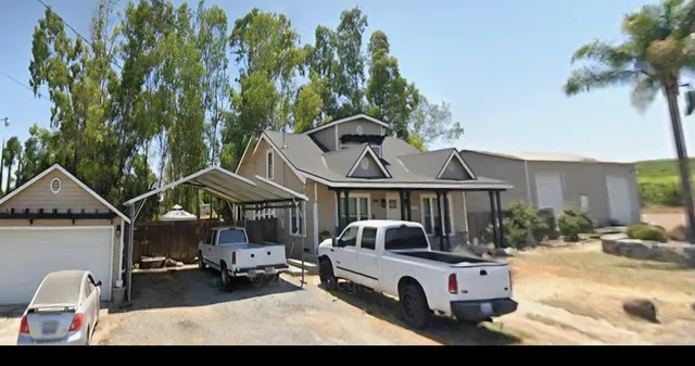 a white house covered with tall trees