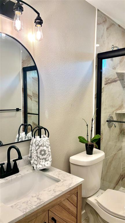 4603 Junius Street, Unit 8 Dallas, TX 75246 - Photo 9 of 16 Full bathroom featuring vanity and tiled shower with glass shower doors.