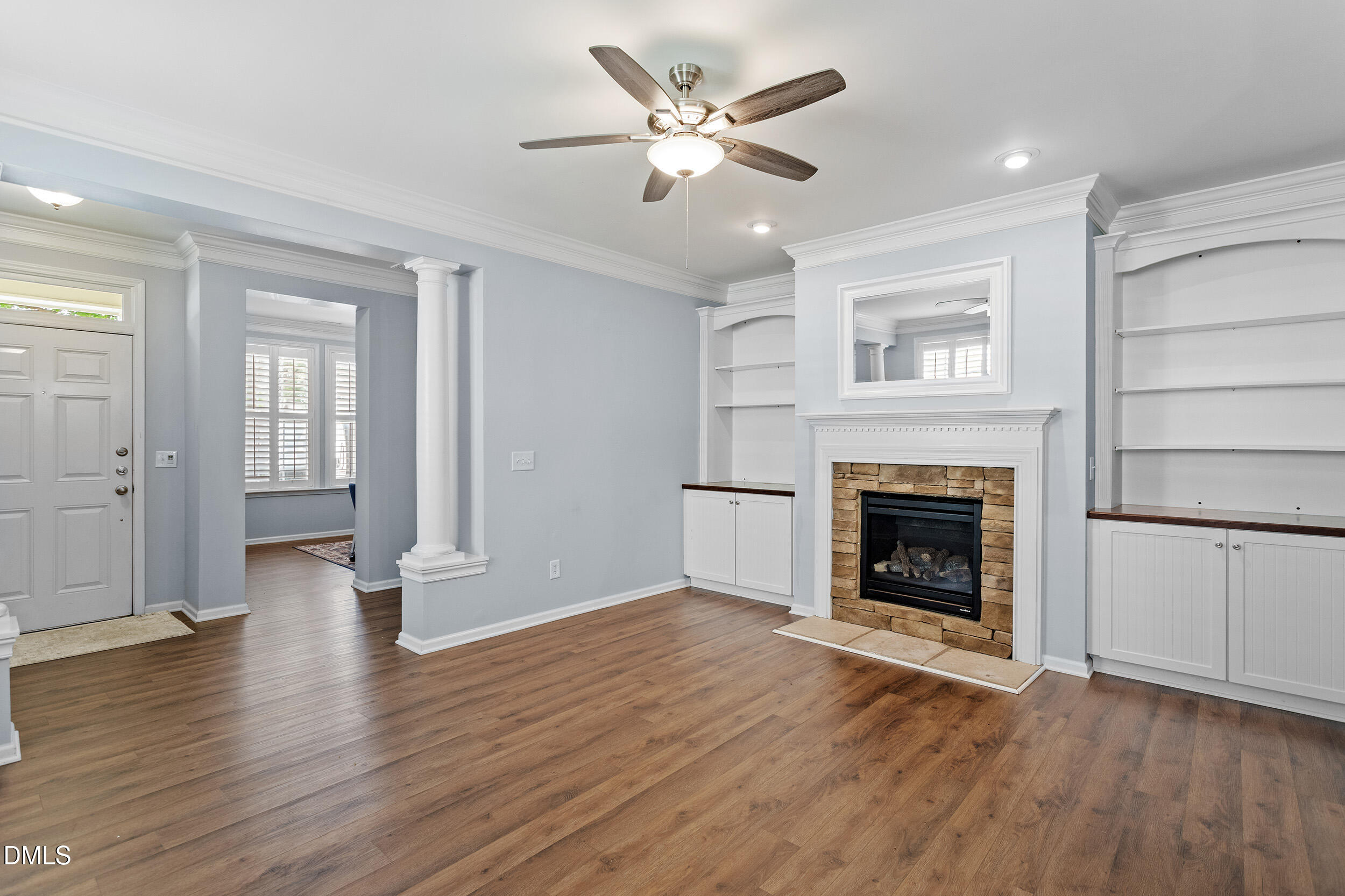 3147 Rapid Falls Road Cary, NC 27519 - Photo 13 of 34 an empty room with wooden floor a fireplace a ceiling fan and windows