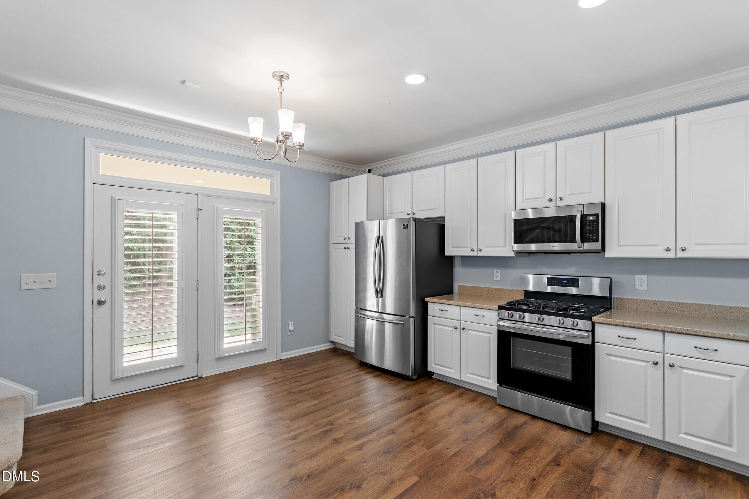 3147 Rapid Falls Road Cary, NC 27519 - Photo 14 of 34 a kitchen with stainless steel appliances a stove top oven a refrigerator a sink and dishwasher with wooden floor