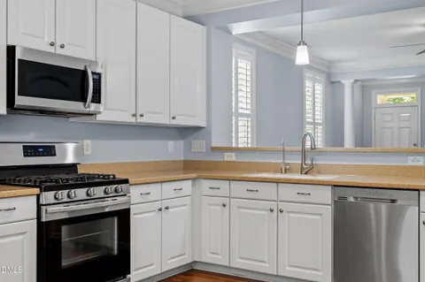 a kitchen with granite countertop white cabinets and appliances