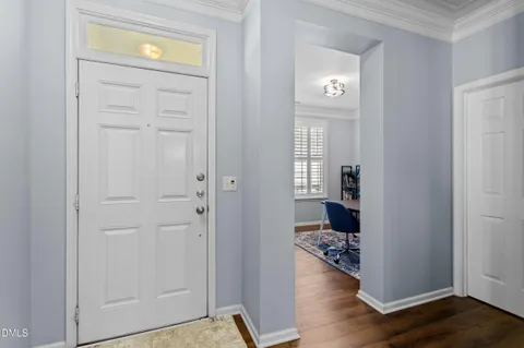 a view of a hallway with wooden floor windows and kitchen view