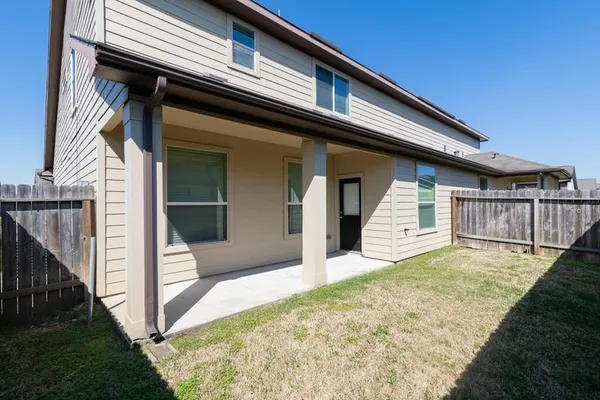 a view of backyard with small cabin and wooden fence