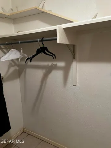 a view of a refrigerator in kitchen and a window in a room