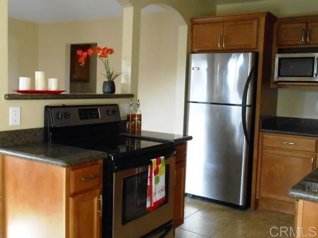 a kitchen with stainless steel appliances granite countertop a refrigerator and a stove