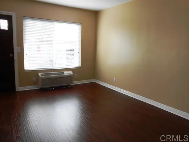 a view of room with window and wooden floor