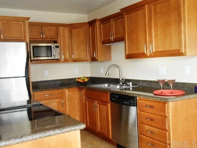 a kitchen with stainless steel appliances granite countertop a sink stove and microwave