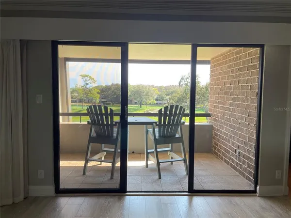 a view of a room with wooden floor and a floor to ceiling window
