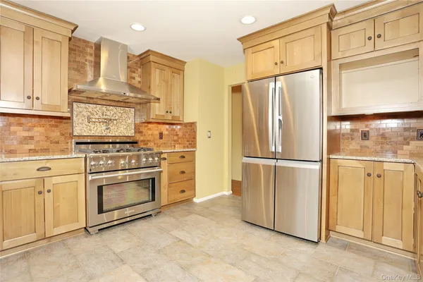a kitchen with granite countertop a sink window and stainless steel appliances