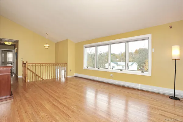 a view of a room with wooden floor and a window