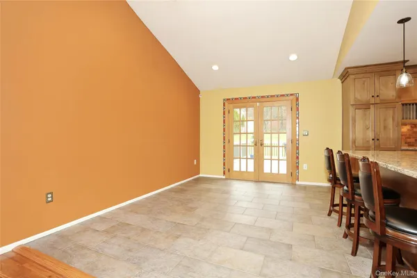 a view of a kitchen with kitchen island granite countertop lots of counter top and chairs