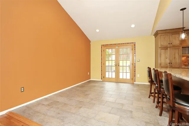 a view of a kitchen with kitchen island granite countertop lots of counter top and chairs
