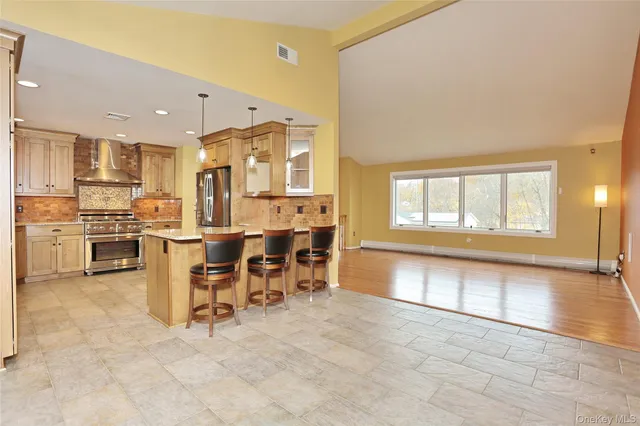 a kitchen with granite countertop cabinets stainless steel appliances a sink and a window