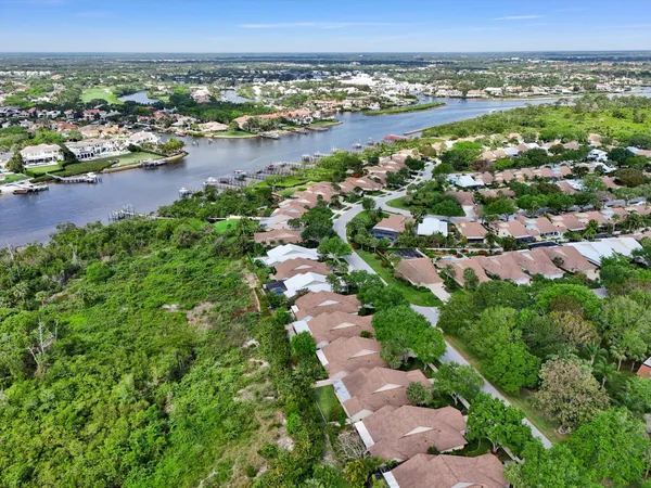 an aerial view of residential houses with outdoor space and trees