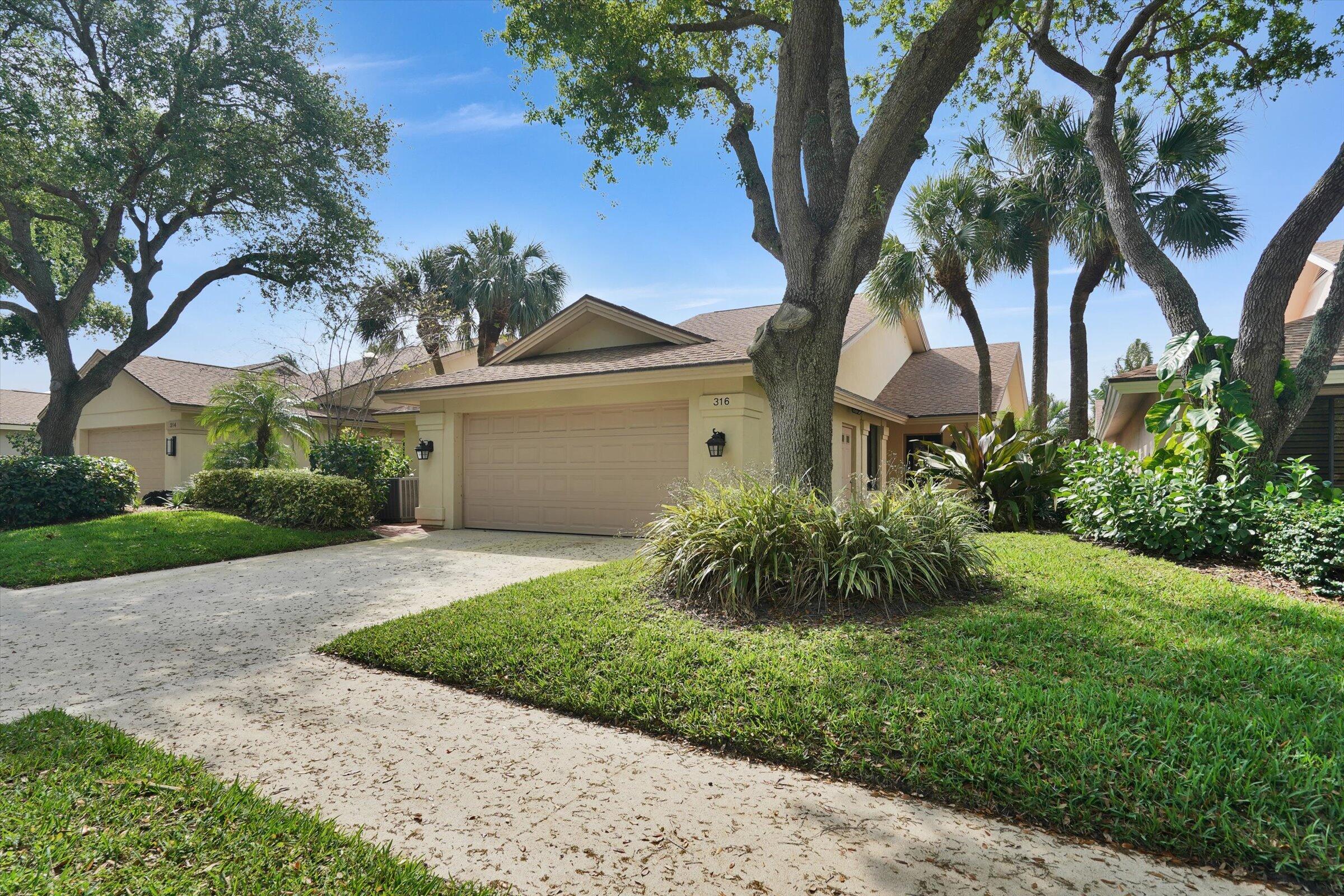 316 River Edge Road Jupiter, FL 33477 - Photo 20 of 53 a front view of a house with a garden