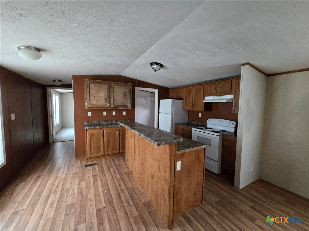 1911 Wald Road, Unit 9 New Braunfels, TX 78132 - Photo 4 of 14 a kitchen with stainless steel appliances granite countertop a refrigerator a stove and a wooden floors